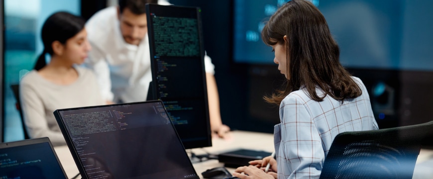 IT security team monitoring cloud data protection on multiple screens in operations center