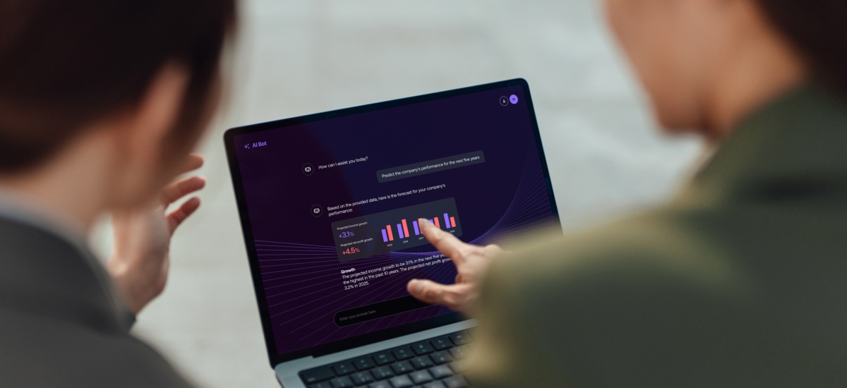Two people review AI-generated analytics and charts on a laptop during a business discussion.