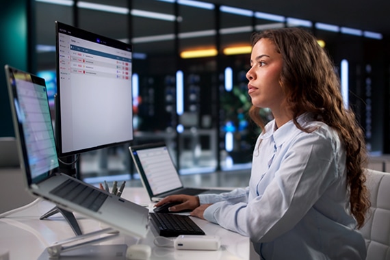 lifestyle card image of a woman reviewing security features on a laptop computer