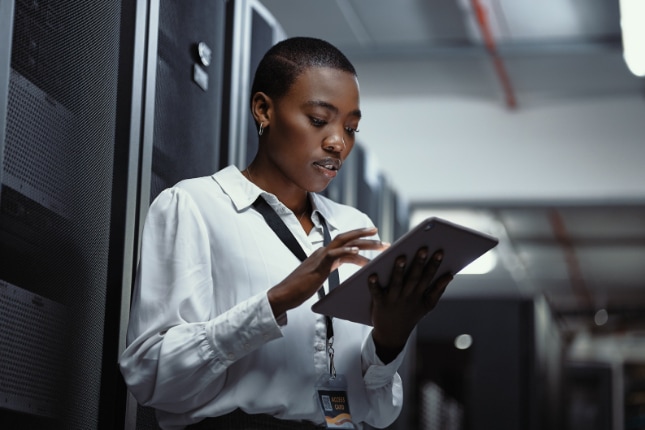 Female programmer doing maintenance in a datacenter.