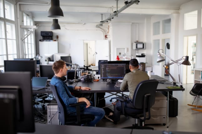 IT administrators working on computers in office.