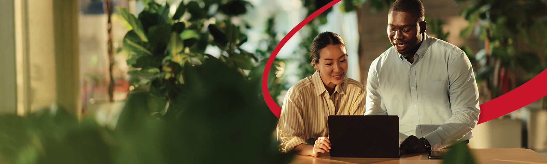 image of two employees working together on a laptop computer in an office setting
