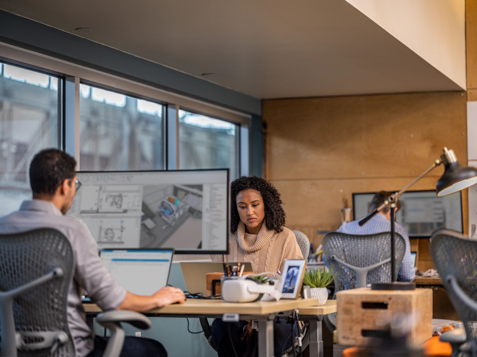 People in an office working on CAD software.