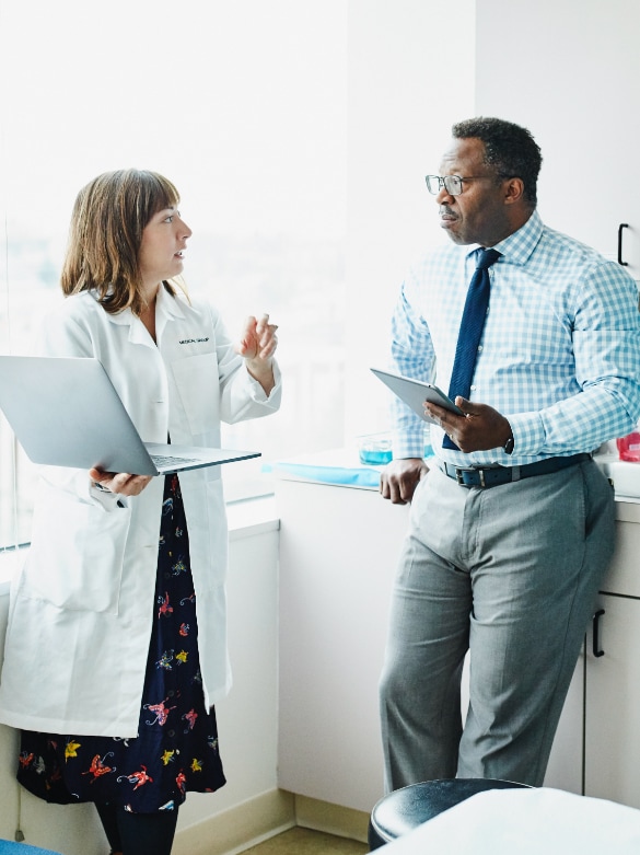 Female doctor talking with IT guy.