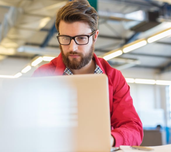 Close up image of a man looking at laptop screen.