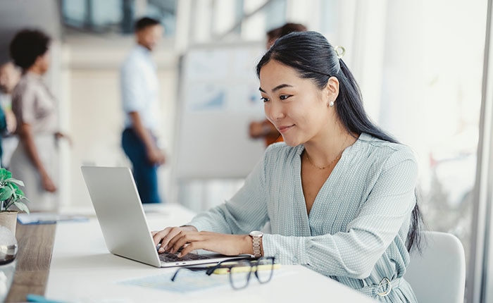 Professional woman working on a laptop in a modern office, representing CDW’s all-in-one business and IT partnership solutions powered by Salesforce expertise.