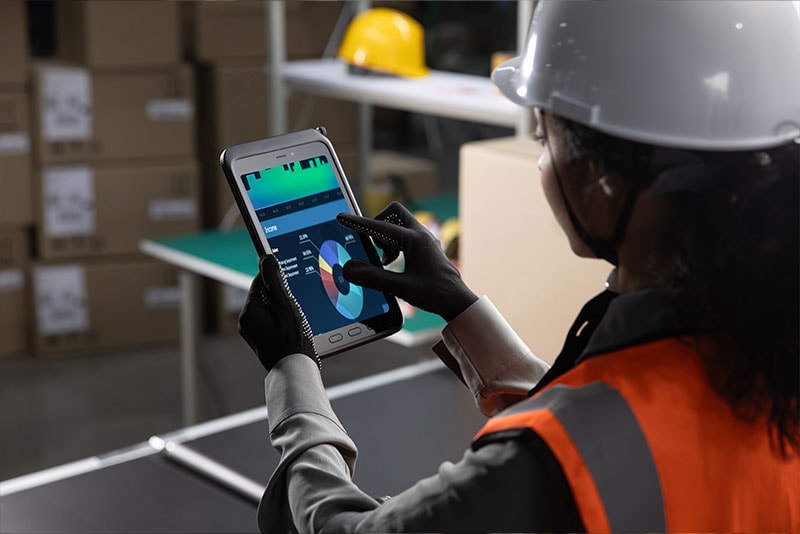 Worker looking at tablet while at work in warehouse