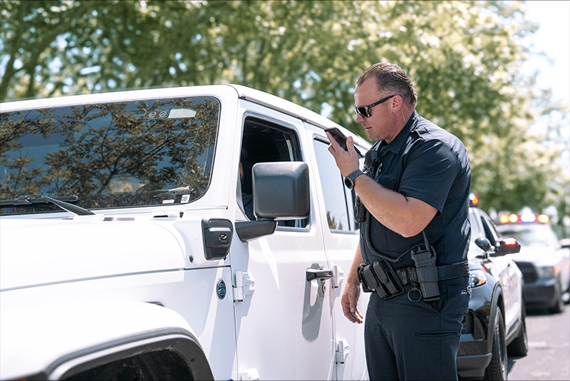 thumbnail image of a police officer using a Samsung mobile phone during a traffic stop