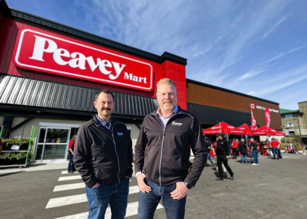 Peavey Industries' founders standing in front of a Peavey mart store.