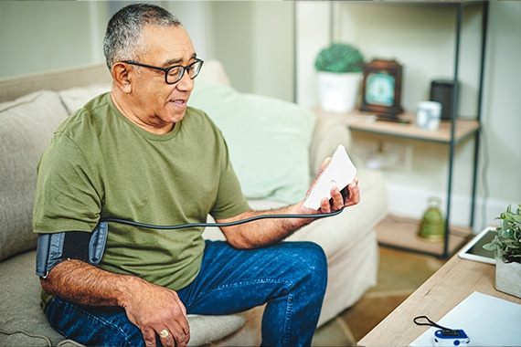 Senior man taking his blood pressure at home