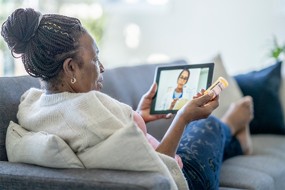 Senior woman holding a tablet on a telehealth appointment call with a doctor