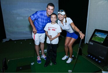 Gary Woodland and Allison Lee posing in simulator at CDW Tech Fore! Kids event