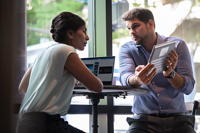 image of two coworkers reviewing data on a tablet device