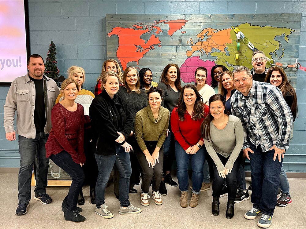 CDW coworkers pose in front of world map