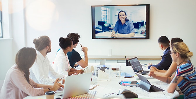 Image of men and woman having a video conference meeting in room of office.