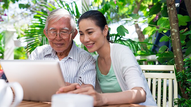 Image of nurse with senior man looking at tablet device.