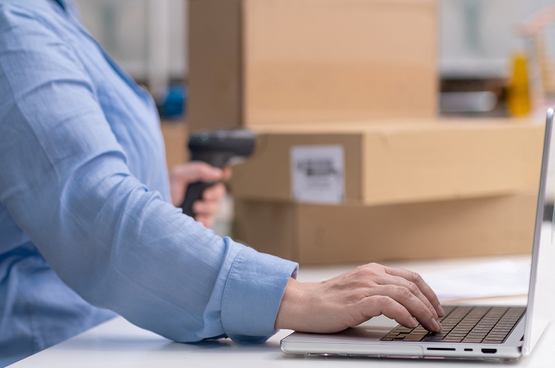 supply-chain-as-a-service-img1-800 ALT TEXT: Person scans box and types on laptop at desk.