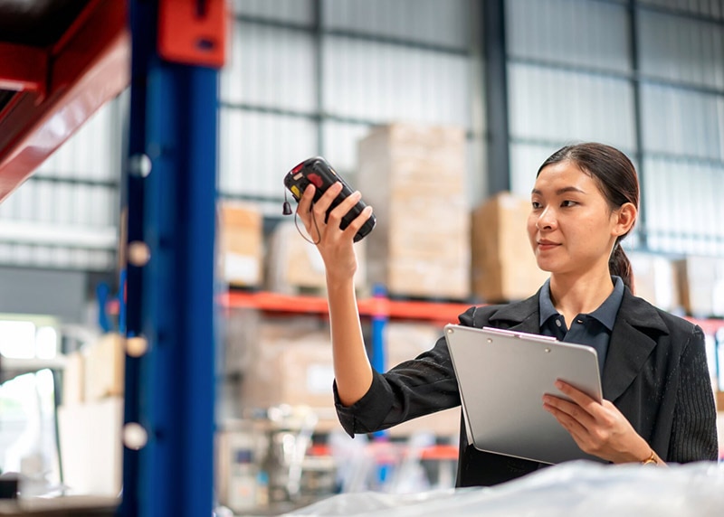 Warehouse manager with scanner making review of goods in warehouse for check the quantity and prepare data for send to warehouse management.