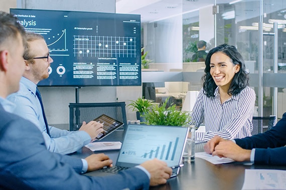 Colleagues seated at conference table participating in a video conference call