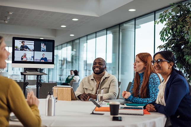 thumbnail image of employees on a video conference call inside a meeting room