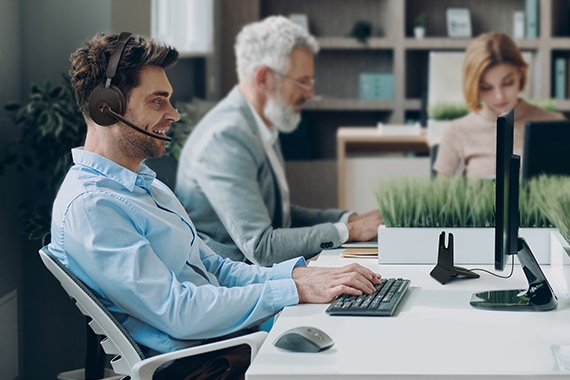 card thumbnail of a man using a headset while on a conference call inside a meeting room