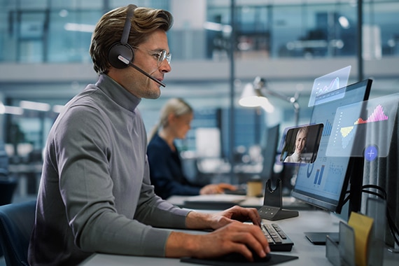 man wearing a Yealink headset working on a computer