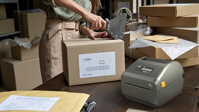 Person mailing packages and using Zebra label printer.